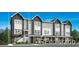 Modern townhome featuring dark gray siding, a covered porch, and an elevated front entry at 700 Saddle Dr, Erie, CO 80516