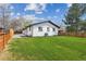 Lush green backyard with well-maintained lawn, a modern fence, and a renovated white home at 290 Beryl Way, Broomfield, CO 80020