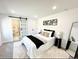 Well-lit bedroom boasts a sliding barn door to bathroom, modern décor and a comfortable layout at 290 Beryl Way, Broomfield, CO 80020