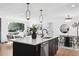 Open concept kitchen with black cabinets, stainless steel appliances and a bright countertop breakfast bar at 290 Beryl Way, Broomfield, CO 80020