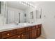 Bright bathroom with dual sinks, wood cabinets, and bright lighting at 2250 Indian Paintbrush Cir, Highlands Ranch, CO 80129