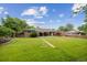 Expansive backyard with lush green lawn, landscaping, and a covered patio at 3384 W Arlington Ave, Littleton, CO 80123