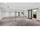 Large basement with carpet and exposed beams, leading to a bathroom and stairs at 3384 W Arlington Ave, Littleton, CO 80123