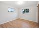 Bright bedroom featuring hardwood floors, white walls, and double-paned windows at 3384 W Arlington Ave, Littleton, CO 80123