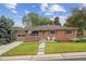 Charming red brick single-story home with a well-manicured lawn and an attached one car garage at 3384 W Arlington Ave, Littleton, CO 80123