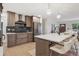 Modern kitchen featuring a waterfall island, counter seating, stainless appliances, and custom cabinets at 3384 W Arlington Ave, Littleton, CO 80123