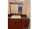 Bathroom vanity with granite countertops, a square sink, and wood cabinets at 7665 E Eastman Ave # 110C, Denver, CO 80231