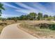Scenic park view featuring a curved pathway, grassy fields, mature trees, and park benches at 7665 E Eastman Ave # 110C, Denver, CO 80231
