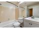 Bathroom features a white sink, toilet, bathtub, and beige tile walls at 1811 S Quebec Way # 187, Denver, CO 80231