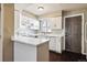 Well-maintained kitchen featuring white cabinets, modern appliances, and a convenient breakfast bar at 1811 S Quebec Way # 187, Denver, CO 80231