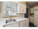 Kitchen showcases white cabinets, countertops, appliances, sink, and a window at 1811 S Quebec Way # 187, Denver, CO 80231