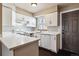 Bright kitchen features white cabinets, countertops, appliances, and a window over the sink at 1811 S Quebec Way # 187, Denver, CO 80231