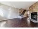 Spacious living room with hardwood floors, a stone fireplace, and access to the staircase at 1811 S Quebec Way # 187, Denver, CO 80231