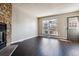 Inviting living room featuring hardwood floors, a cozy stone fireplace, and plenty of natural light at 1811 S Quebec Way # 187, Denver, CO 80231