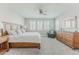 Bright bedroom featuring a king-size bed, ceiling fan, plantation shutters, and a decorative armchair for relaxation at 16383 Ute Peak Way, Broomfield, CO 80023