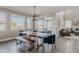 Bright dining area featuring a wood table, blue chairs, and large windows with neighborhood views at 16383 Ute Peak Way, Broomfield, CO 80023
