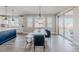 A dining room table with seating under modern light fixture in a dining space with large windows at 16383 Ute Peak Way, Broomfield, CO 80023