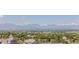 Picturesque view overlooking lush trees and rooftops with majestic snow-capped mountains in the distance at 16383 Ute Peak Way, Broomfield, CO 80023