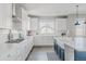 Bright kitchen with white cabinets, modern appliances, and a unique island with a farmhouse sink at 16383 Ute Peak Way, Broomfield, CO 80023