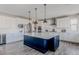 Spacious kitchen features white cabinets, stainless steel appliances, and a large island with modern lighting at 16383 Ute Peak Way, Broomfield, CO 80023