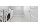 Efficient laundry room equipped with a front-load washer and dryer, storage cabinets, and a bright window at 16383 Ute Peak Way, Broomfield, CO 80023