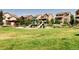 Community playground with slides, climbing structures, lush grass, and surrounding homes at 16383 Ute Peak Way, Broomfield, CO 80023