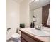 Bathroom with a single sink vanity, toilet, and shower with neutral wall art at 2777 E Geddes Ave, Centennial, CO 80122