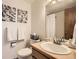 Bathroom with a single sink vanity, toilet, and shower with neutral wall art at 2777 E Geddes Ave, Centennial, CO 80122