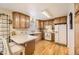 Well-lit kitchen with wooden cabinets, a white refrigerator, and breakfast bar seating at 2777 E Geddes Ave, Centennial, CO 80122