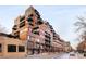 Attractive brick apartment building featuring multiple balconies and a street-level entrance with well-maintained sidewalks at 1499 Blake St # 6A, Denver, CO 80202