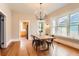 Bright dining room with wood floors, modern chandelier, and many windows for ample natural light at 722 Kimbark St, Longmont, CO 80501