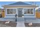 Close-up of attractive single-Gathering home entrance with tidy landscaping, a wreath, and covered porch at 722 Kimbark St, Longmont, CO 80501