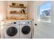 Convenient laundry room with modern washer and dryer, open shelving, and natural light at 722 Kimbark St, Longmont, CO 80501