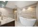 Bathroom featuring soaking tub and stone tile accent wall and shower at 8724 Armadillo Trl, Evergreen, CO 80439
