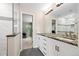 Bright bathroom features double vanity, shower and view to bedroom at 8724 Armadillo Trl, Evergreen, CO 80439