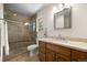 Bathroom featuring a glass enclosed shower, stone tile, and a wooden vanity with light countertop at 8724 Armadillo Trl, Evergreen, CO 80439