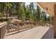 Inviting outdoor deck with a wooden floor, offering scenic views of the surrounding trees at 8724 Armadillo Trl, Evergreen, CO 80439