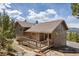Exterior showcasing a multi-story home with a back deck and manicured surroundings at 8724 Armadillo Trl, Evergreen, CO 80439
