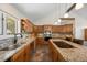 Bright kitchen with granite countertops, stainless steel appliances, an island cooktop, and lots of wood cabinetry at 8724 Armadillo Trl, Evergreen, CO 80439