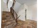 Carpeted staircase with dark wood banister, leading to upper level, surrounded by tile flooring at 8724 Armadillo Trl, Evergreen, CO 80439