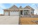 Two-story house with gray siding, stone accents, and a two-car garage at 15740 Spruce St, Thornton, CO 80602