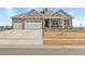 Two-story house with gray siding, stone accents, and a two-car garage at 15740 Spruce St, Thornton, CO 80602