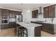 Modern kitchen with dark cabinets, white countertops and island with seating at 15740 Spruce St, Thornton, CO 80602