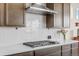 Kitchen detail showing gas cooktop and white subway tile backsplash at 15740 Spruce St, Thornton, CO 80602