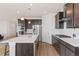 Modern kitchen with island, dark cabinets and stainless steel appliances at 15740 Spruce St, Thornton, CO 80602