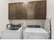 Bright laundry room, washer, dryer, and cabinets at 15740 Spruce St, Thornton, CO 80602