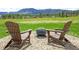 Inviting backyard patio featuring Adirondack chairs and fire pit with mountain views at 609 Pioneer Camp Vw, Palmer Lake, CO 80133