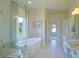 Bright bathroom featuring a soaking tub, glass shower, and marble countertops at 609 Pioneer Camp Vw, Palmer Lake, CO 80133