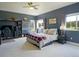 Large bedroom featuring a bed, a desk, a shelving unit, and two windows at 609 Pioneer Camp Vw, Palmer Lake, CO 80133
