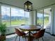 Bright dining room featuring mountain views, a round table, and modern light fixture at 609 Pioneer Camp Vw, Palmer Lake, CO 80133